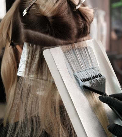A young woman in a hairdressing salon dyes her hair blond. Hair coloring process